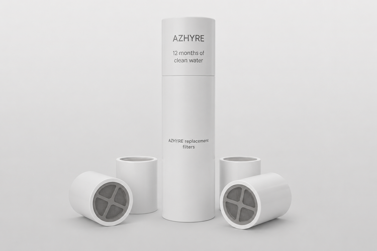 A white cylindrical AZHYRE filter canister stands upright in the center with four matching white filter cartridges arranged around it on a clean light gray studio background.